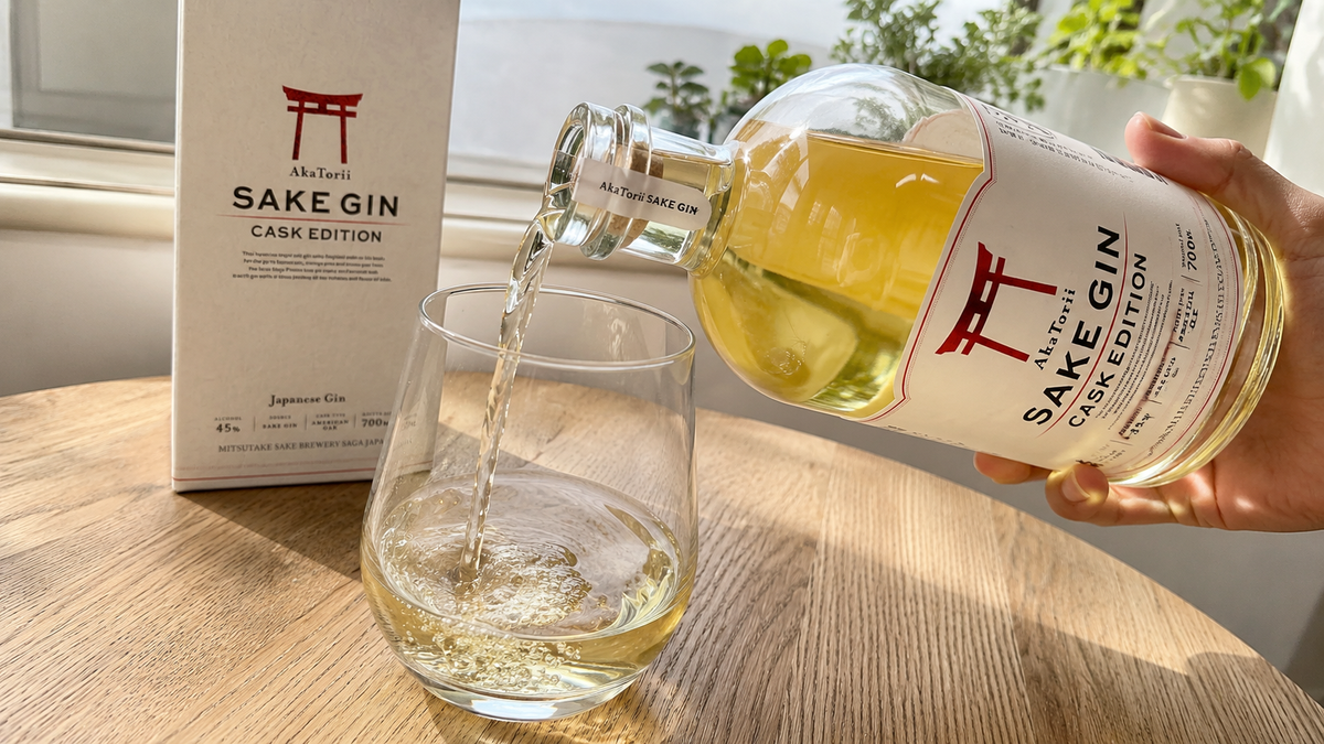 窓際でグラスに注がれる琥珀色の赤鳥居 SAKE GIN